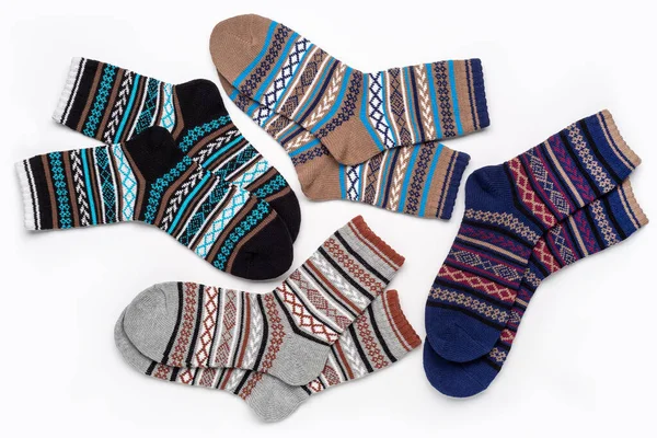 A set of multi-colored knitted socks with an ornament. The concept of  cozy home atmosphere in winter. Socks background.