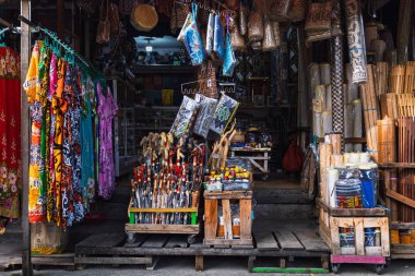 Balikpapan, Endonezya - 3 Ağustos 2025. Geleneksel market tezgahları renkli elbiseler, el sanatları, tahta çubuklar ve hediyelik eşyalar satıyor..