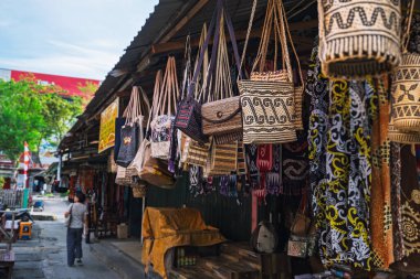 Balikpapan, Endonezya - 3 Ağustos 2025. Yerel bir markette el yapımı dokuma poşetler ve geleneksel kumaşlar sergileniyor.. 
