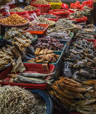 Geleneksel Endonezya pazarında sepet ve tepsilerde sergilenen çeşitli kurutulmuş balık, ançüez ve deniz ürünleri..