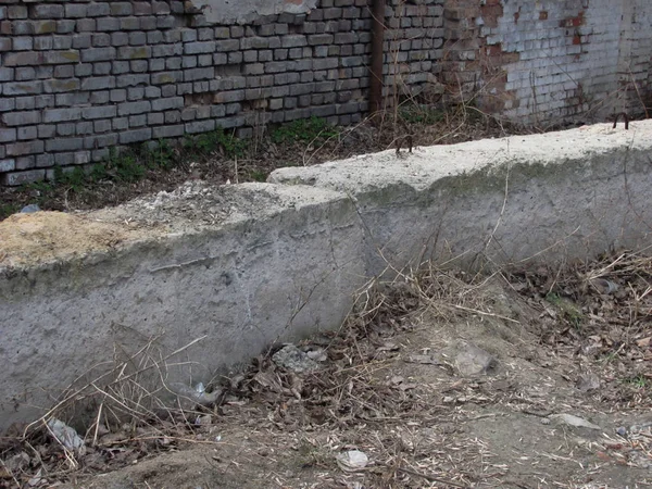 Pared de ladrillo en ruinas, bloques de hormigón y suelo — Foto de Stock