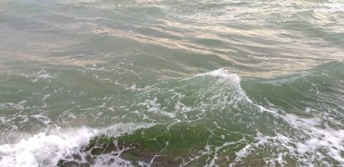 Yeşil deniz dalgaları arka planda dinleniyor