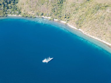 Lembata, Endonezya yakınındaki güzel bir mercan kayalığı yakınındaki küçük bir Pinisi yelkenli yelken. Bu uzak, tropikal bölge, Mercan Üçgeni içinde olağanüstü deniz biyolojik çeşitlilik limanlar.