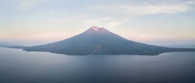The dramatic volcano of Ile Ape rises on the island of Lembata in Indonesia. This remote, tropical region, within the Coral Triangle, harbors extraordinary marine biodiversity. clipart
