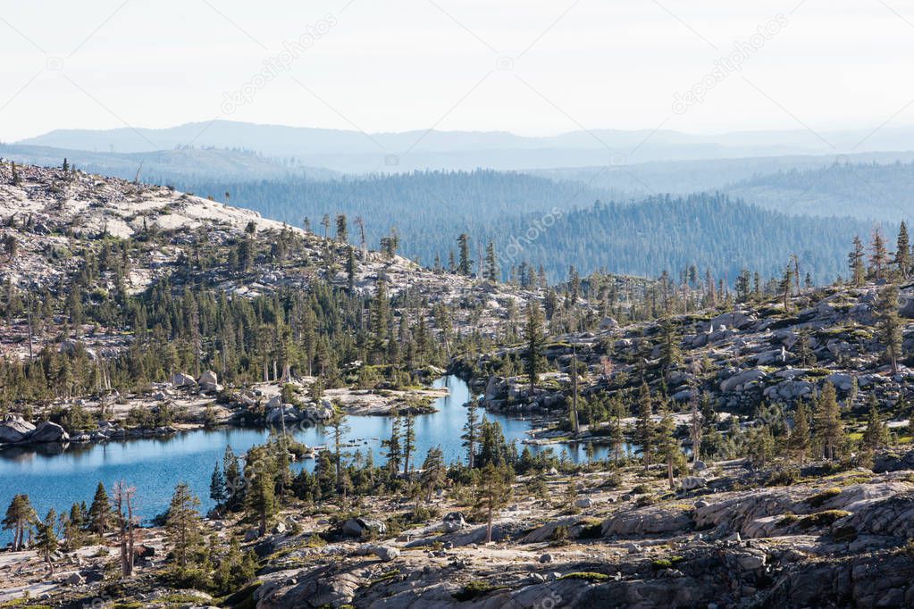 A beautiful, remote lake, Twin Lake, is surrounded by granite rock in the Desolation Wilderness of the Sierra Nevada Mountains in Northern California. This is a popular area for backpacking and camping.