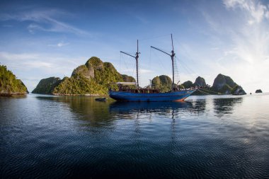 Pinisi geminin Wayag, Raja Ampat, Endonezya sıcak sularda aittir. Bu uzak, tropikal bölge inanılmaz yüksek deniz biyoçeşitliliği nedeniyle Mercan Üçgeni kalbinde olarak bilinir.