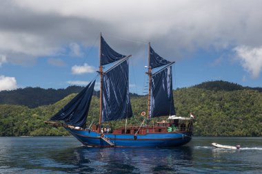 Güzel bir Pinisi schooner Raja Ampat, Endonezya sakin sularda yelken. Bu uzak, tropikal bölge inanılmaz deniz biyoçeşitliliği nedeniyle Mercan Üçgeni kalbinde olarak bilinir.