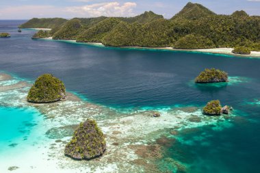 Kireçtaşı Adaları Wayag, Raja Ampat, Endonezya'da muhteşem bir lagün üzerinden yükselir. Bu uzak, tropikal bölge inanılmaz deniz biyoçeşitliliği nedeniyle Mercan Üçgeni kalbinde olarak bilinir.