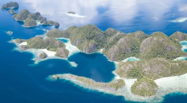 Dramatik kireçtaşı Adaları Raja Ampat, Endonezya, güzel deniz manzarası üzerinden yükselir. Bu uzak bölgede yüksek deniz biyoçeşitliliği nedeniyle Mercan Üçgeni kalbinde olarak bilinir.