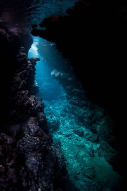 Kirişler güneş ışığı Solomon Adaları'nda bir sualtı mağara gölgeler içine inerler. Biodiverse mercan resifleri bu bölgenin yarıklar, çatlaklar ve mağaraları ile delik deşik.
