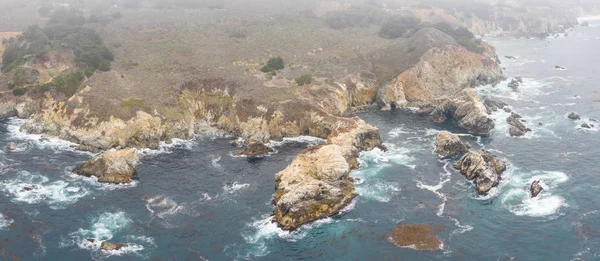 The nutrient-rich waters of the North Pacific Ocean wash against the rocky and scenic coastline of Northern California not far from Monterey. Kelp forests thrive in this coastal environment.