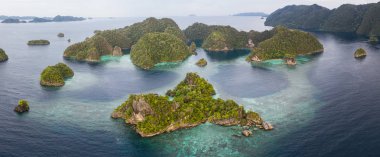 Yukarıda da görüleceği, sığ bir mercan kayalığı Raja Ampat, Endonezya uzak bir ada çevreleyen. Bu biodiverse bölge, onun muhteşem deniz yaşamı nedeniyle Mercan Üçgeni 