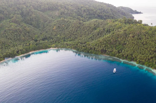 An aerial view of the remote island of New Ireland in Papua New Guinea shows beautiful lagoon scenery. This remote area is part of the Coral Triangle due to its high marine biodiversity.