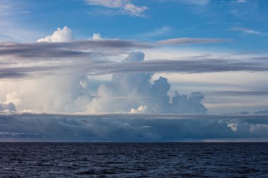 Papua Yeni Gine'deki New Britain yakınındaki deniz manzarası üzerinde bulutlar toplanıyor. Bu uzak tropikal bölge onun ıslak hava ve limanları olağanüstü deniz biyolojik çeşitlilik için tanınır.