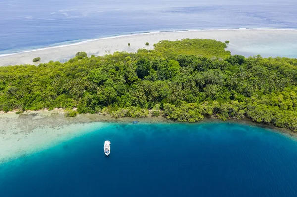 A small dive boat is anchored off the coast of New Britain in Papua New Guinea. This remote, tropical area is part of the Coral Triangle due to its high marine biodiversity.