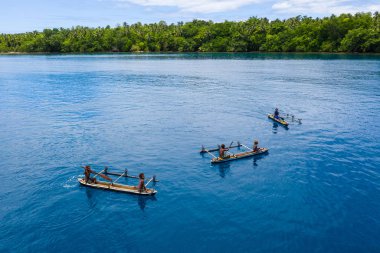 Köydeki çocuklar şelale Bay, yeni Britanya, Papua Yeni Gine'nin sakin outrigger kano kürek. Denge ayakları hala ulaşım Melanezya uzak bölgelerinde en yaygın anlamı vardır.