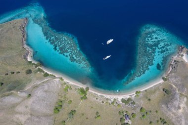 Kuş bakışı bakıldığında, pastoral bir ada Komodo Milli Parkı, Endonezya sağlıklı bir mercan resifi ile çevrilidir. Bu tropik alan, deniz biyolojik çeşitliliği nin yanı sıra ejderhaları ile de bilinir..