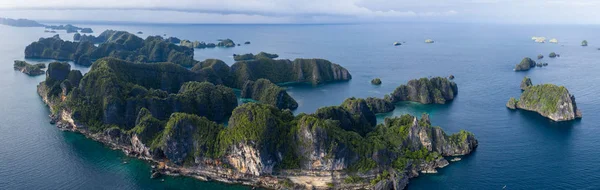 Seen from a bird\'s eye view, impressive limestone islands rise from the seascape of Raja Ampat, Indonesia. This remote, tropical area is known for its marine biodiversity.