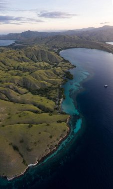 Seen from a bird's eye view, dawn breaks over scenic islands in Komodo National Park, Indonesia. This tropical area is known for its marine biodiversity as well as its dragons. clipart