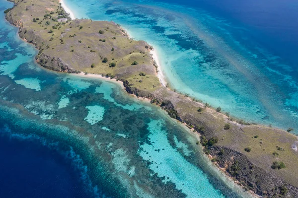 从鸟瞰图上看 在印度尼西亚科莫多国家公园 一个狭窄的半岛被一个健康的珊瑚礁所环绕 这个热带地区以其海洋生物多样性和龙而闻名 — 图库照片