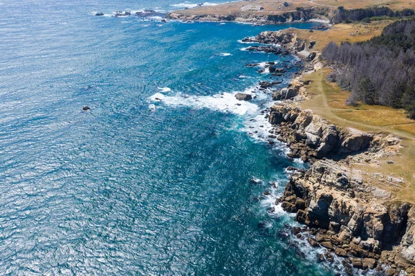Seen from a bird\'s eye view, the Pacific Ocean washes against the rocky coast of Northern California in Sonoma. This beautiful area runs parallel to the famed Pacific Coast Highway.