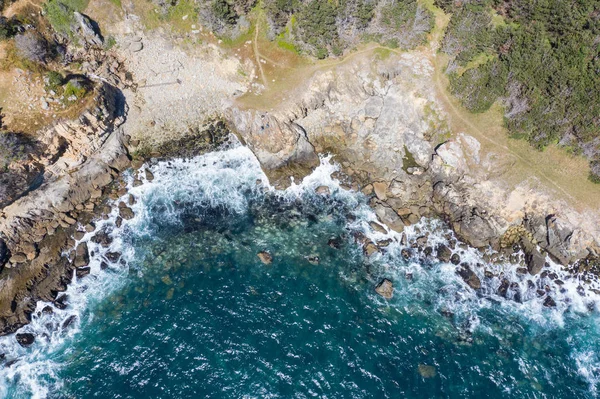 Seen from a bird\'s eye view, the Pacific Ocean washes against the rocky coast of Northern California in Sonoma. This beautiful area runs parallel to the famed Pacific Coast Highway.
