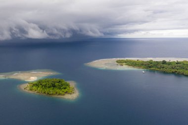 Yağmur bulutları Papua Yeni Gine'deki küçük, tropikal adalara yaklaşırken Pasifik Okyanusu'nu süpürür. Squalls tropik yaygındır ve hızlı bir şekilde gelip gitmek.