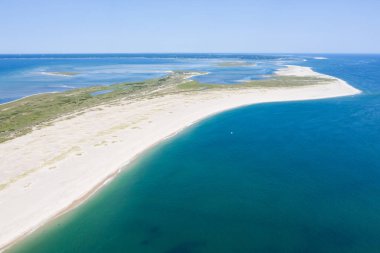 The cold waters of the Atlantic Ocean bathe a scenic beach on Cape Cod, Massachusetts. This beautiful area of New England, not too far from Boston, is a popular summer vacation destination. clipart