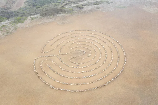 A circular rock labyrinth is found on the edge of the Pacific Ocean just north of San Francisco, California. Labyrinths symbolize the journey through life from birth to spiritual awakening to death.