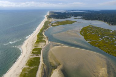 Atlantik Okyanusu, Orléans, Cape Cod, Massachusetts 'teki manzaralı Nauset Sahili' ne karşı kıyıya vurur. Bu estetik halk plajı yaz aylarında tatil yapan insanlar için popüler bir yerdir.. 