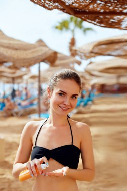  Güneş kremi şişe onun elinde tutan seksi genç kadın bikini. Cilt Bakımı