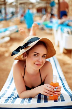 Güneş kremi şişe onun elinde tutan genç kadın bikini. Cilt Bakımı. Bir kadın uygulamak güneş kremi.