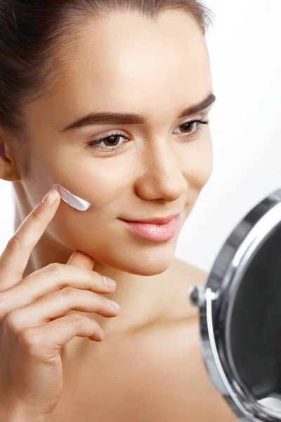 Young Woman Applying Care Cream Her Face Looking Mirror — Stock Photo, Image