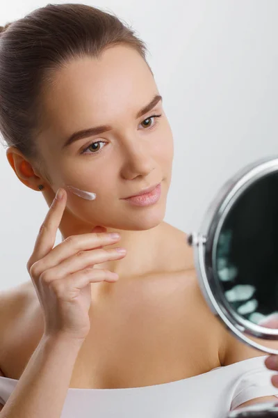 Female Putting Moisturizer Her Facial Skin Holding Mirror Model Isolated — Stock Photo, Image