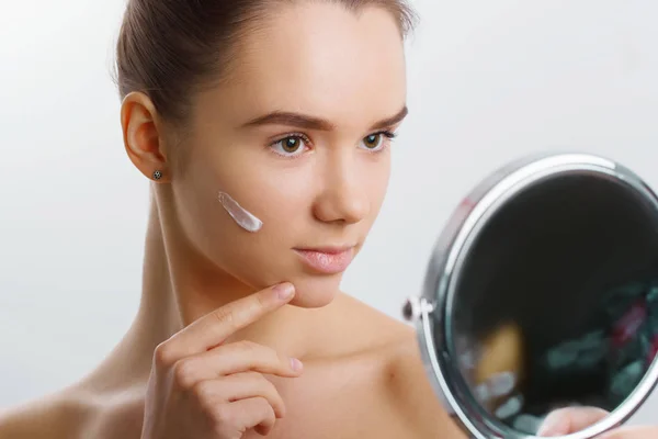 Mujer Poniéndose Crema Hidratante Piel Facial Sosteniendo Espejo Modelo Aislado —  Fotos de Stock