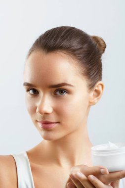 Cilt Bakımı. Güzellik kavramı. Genç güzel kadın Holding kozmetik Cream.Girl taze cilt, antiaging kavramı ile. Spa. Güzellik kavramı. Kadın, taze makyaj ve mükemmel cilt