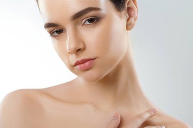 Güzellik yüz. Güzel kadın ile doğal makyaj dokunmatik kendi yüzünü. Temiz cilt kızla. Portre. Kozmetik. Cilt Bakımı. Yüksek çözünürlük