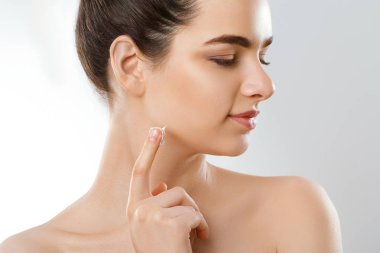 Güzel genç kadın temiz taze cilt ile kendi yüz dokun. Kozmetik, güzellik ve spa.