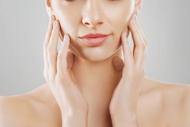 Güzellik ve Spa kavramı. Güzel genç kadın temiz taze cilt ile değmek kendi yüz ve Smiling.Facial tedavi. Kız erkek doğal Makeup.Cosmetology ile.