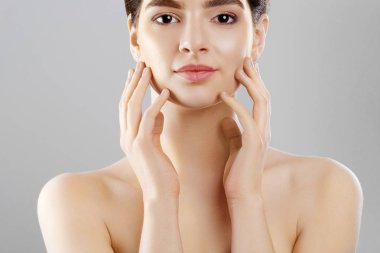 Güzellik ve Spa kavramı. Güzel genç kadın temiz taze cilt ile kendi yüz dokun. Yüz tedavi. Doğal Makeup.Cosmetology kız kadın var. Cilt Bakımı