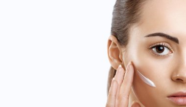 Yüz bakımı. Erkek Cream.Portrait olan genç kadın kozmetik krem cilt üzerinde uygulamak. Yüz dokunmadan yumuşak cilt, doğal makyaj güzellik ürünü ile güzel kız closeup. Yüksek çözünürlük