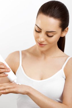 Kadın el kremi. Çıplak makyaj ve doğal manikür ile güzel mutlu kız closeup portresi uygulanan kozmetik nemlendirici el kremi yumuşak ipeksi cilt üzerinde çivi. Güzellik ve vücut bakım kavramı