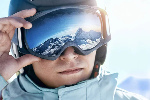雪が降った山の反射で男のスキーゴーグルのクローズ アップ 山の範囲は スキー用マスクに反映されます 山と空の背景にあるスキー リゾートでの男のポートレート — ストック写真