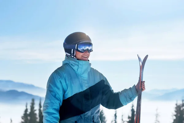 Portrait of a skier in the ski resort on the background of mountains and blue sky, Bukovel.  Ski goggles of a man wearing ski glasses. Winter Sports
