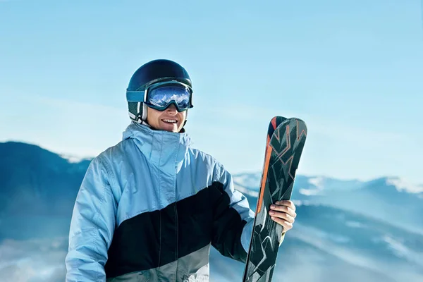 Portrait of a skier in the ski resort on the background of mountains and blue sky, Bukovel.  Ski goggles of a man wearing ski glasses. Winter Sports