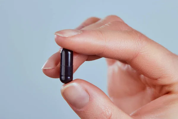 Vitaminler ve diyet takviyeleri. Vitamin hapı elinde tutan kadın. İlaç alarak mutlu kız closeup. Sağlıklı beslenme beslenme kavramı. Aktif kömür kadın elinde görüntü tablet.