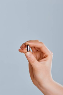 Siyah aktif karbon kapsül gıda zehirlenmesi tedavisi - Image.Vitamins ve Diyet Takviyeler için tutan el.