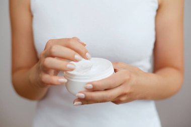 Krem tutarak ve nemlendirici el kremi uygulama kadın el closeup çekim. Güzel eller krema ile. El Cilt Bakımı. Bir kadının vücut losyonu kollarında kullanır. Güzellik ve vücut bakım kavramı 