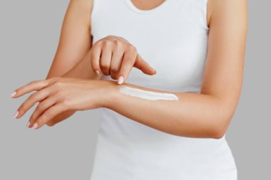 Krem tutarak ve nemlendirici el kremi uygulama kadın el closeup çekim. Güzel eller krema ile. El Cilt Bakımı. Bir kadının vücut losyonu kollarında kullanır. Güzellik ve vücut bakım kavramı 