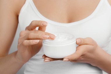 Krem tutarak ve nemlendirici el kremi uygulama kadın el closeup çekim. Güzel eller krema ile. El Cilt Bakımı. Bir kadının vücut losyonu kollarında kullanır. Güzellik ve vücut bakım kavramı 